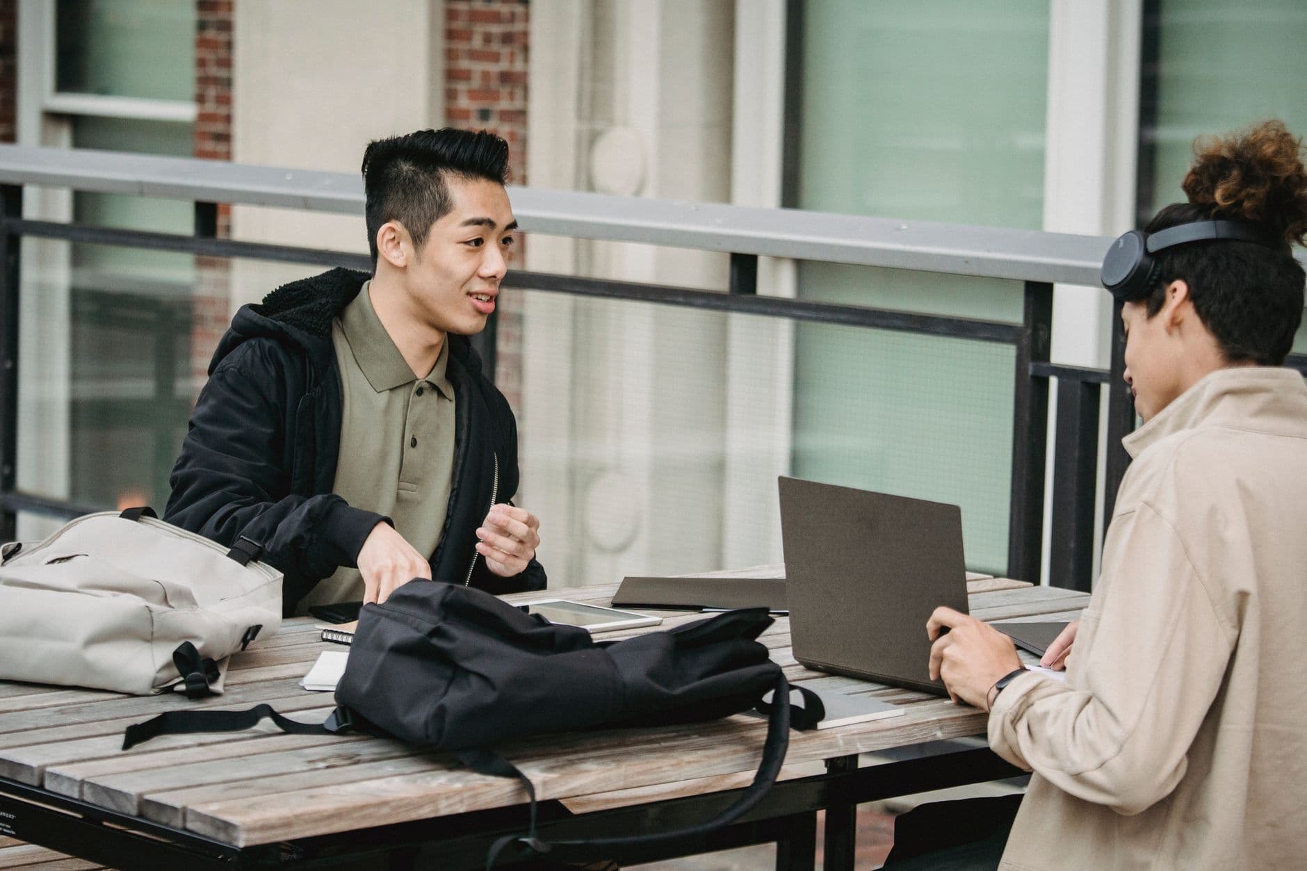 Two students reviewing work together over a laptop