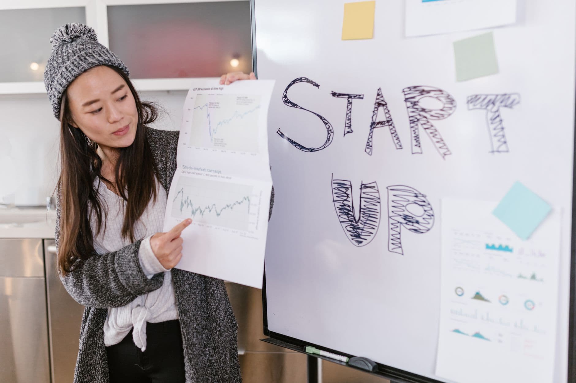 A woman presenting charts to a team in a meeting room