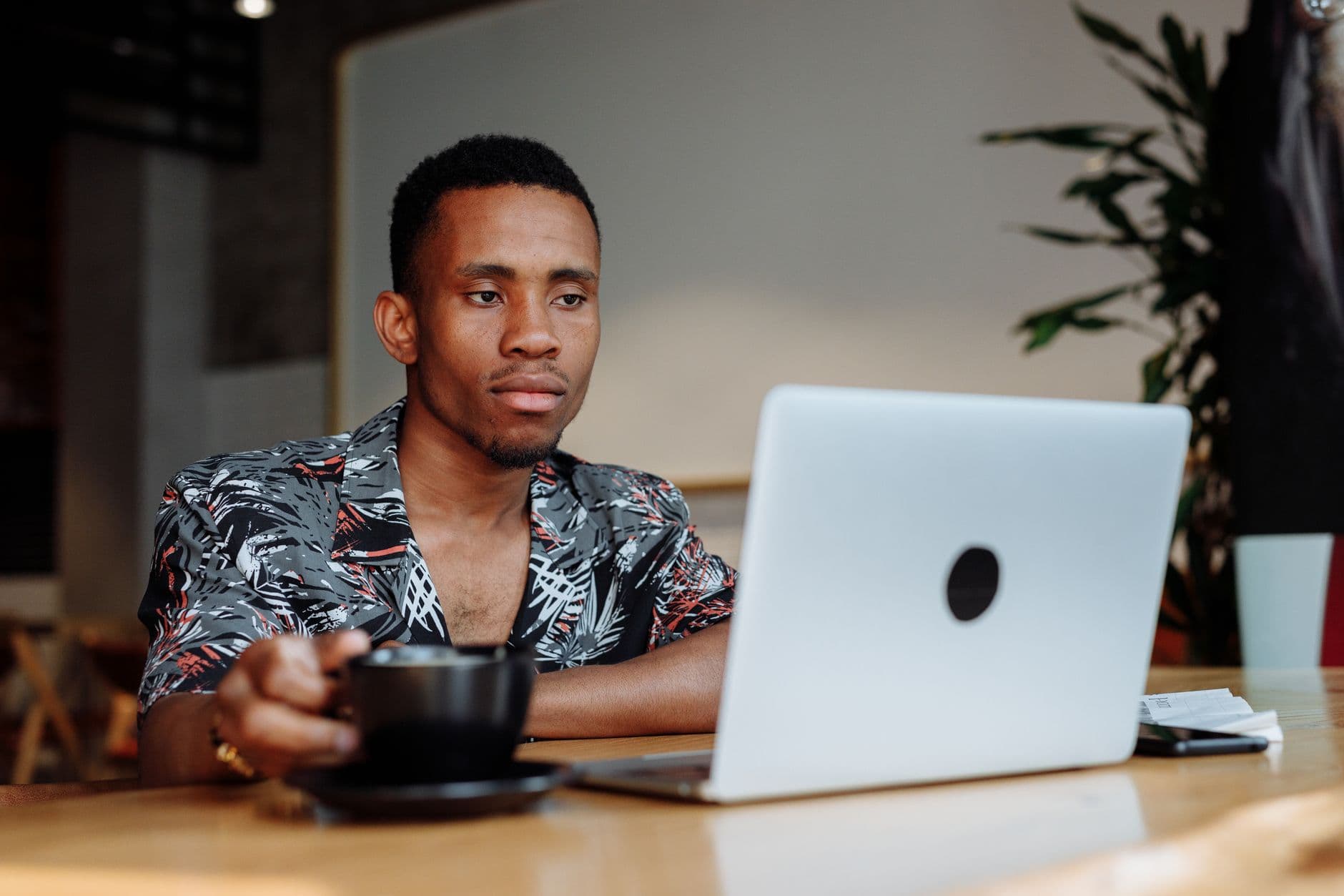A young man working on his laptop in a cafe
